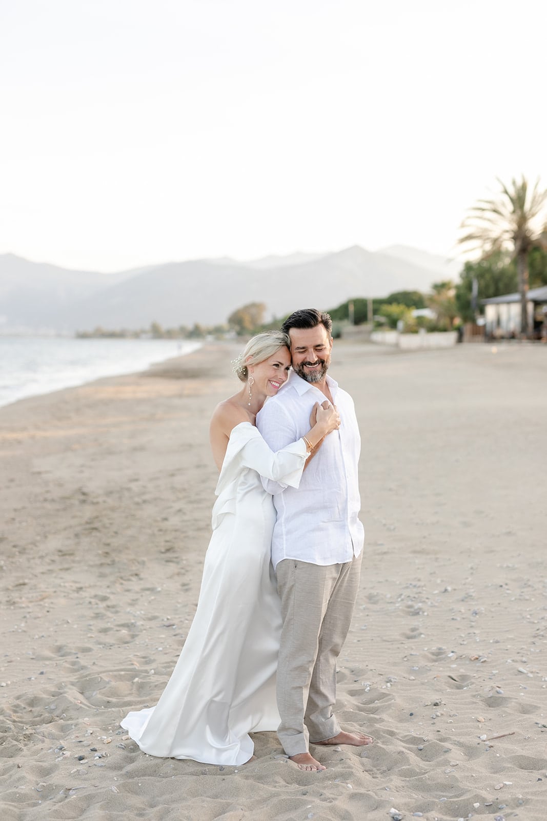 newlywed couple on Schinias beach in casual wedding attire